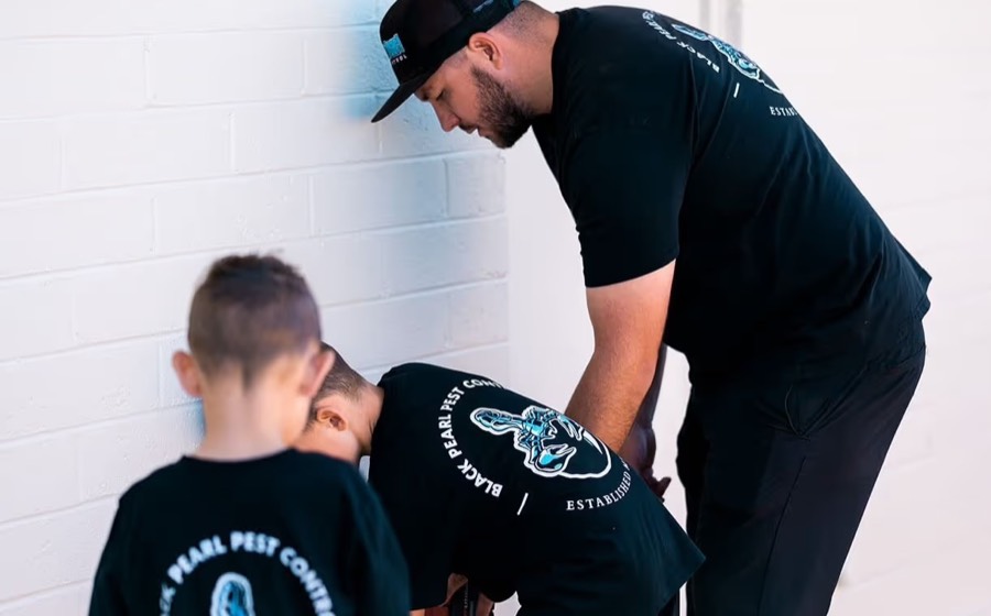 The owner working alongside his two sons, all wearing Black Pearl Pest Control shirts
